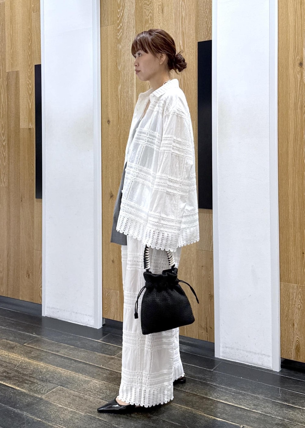 ブラック系のパンプス、グレー系のベスト、ブラック系のショルダーバッグを着用したレディースの春コーディネートの3枚目の写真