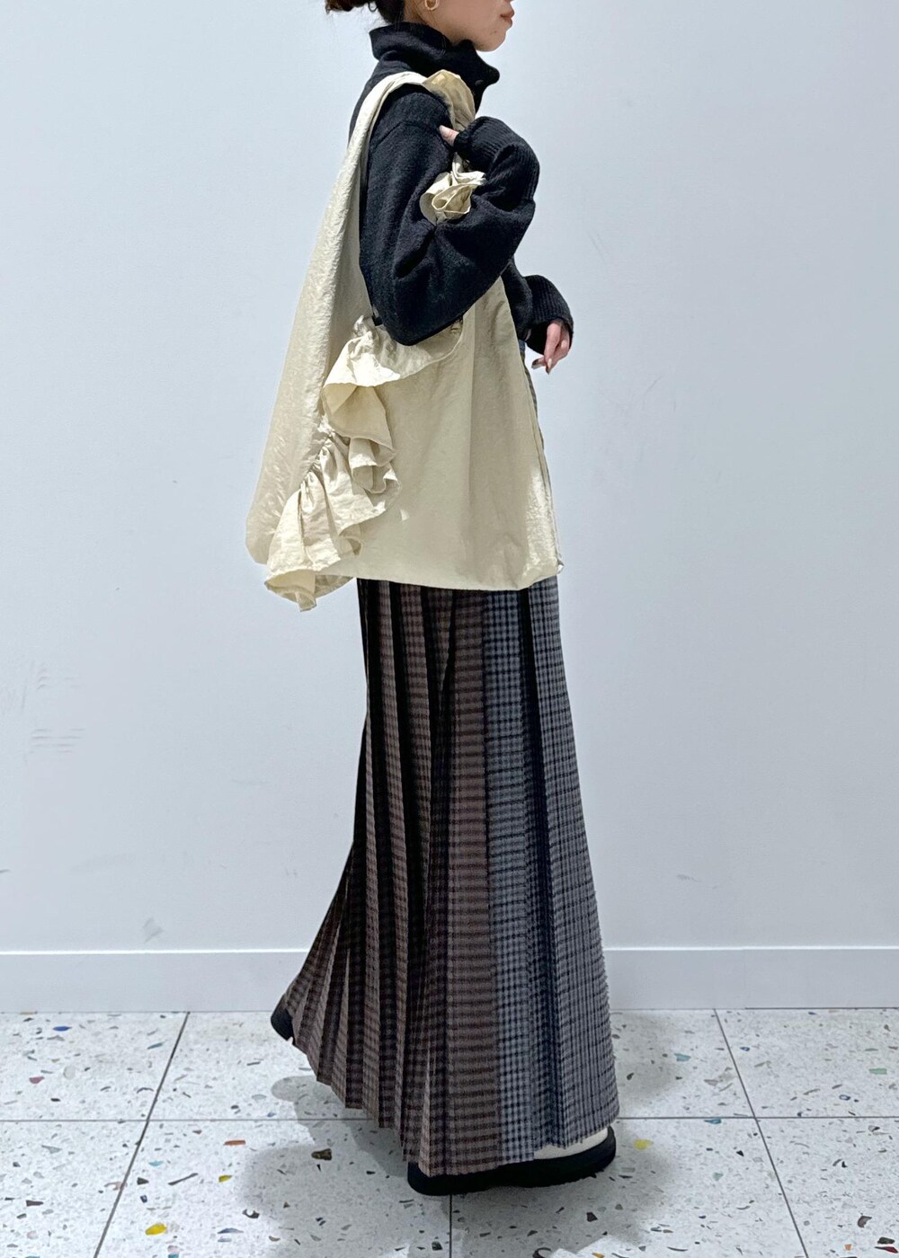 グレー系のスカート、ホワイト系のブーツ、グレー系のカーディガン/ボレロを着用したレディースの秋コーディネートの4枚目の写真