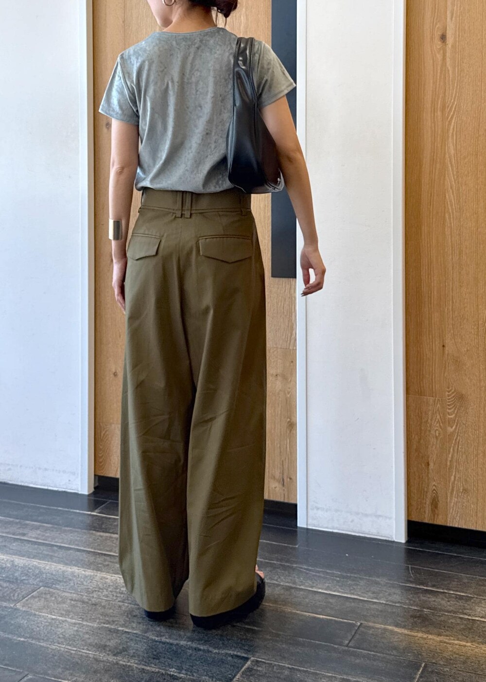 ブラック系のハンドバッグ、ブラック系のサンダル、ブルー系のTシャツ/カットソーを着用したレディースの夏コーディネートの3枚目の写真