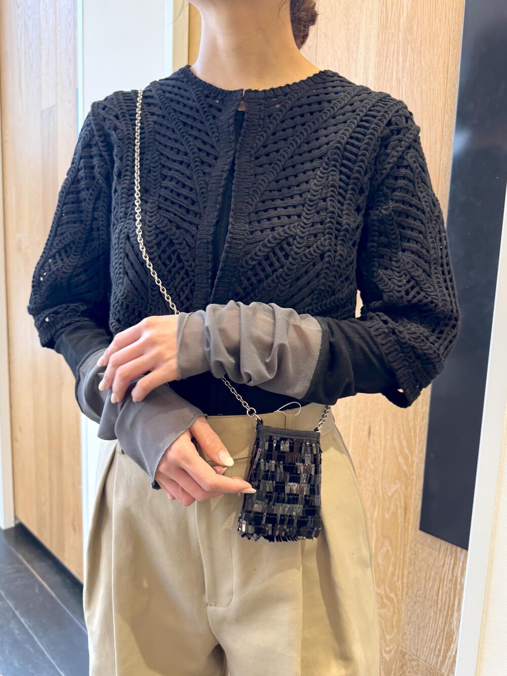 ブラック系のTシャツ/カットソー、ブラック系のショルダーバッグ、ブラック系のカーディガン/ボレロを着用したレディースの冬コーディネートの4枚目の写真