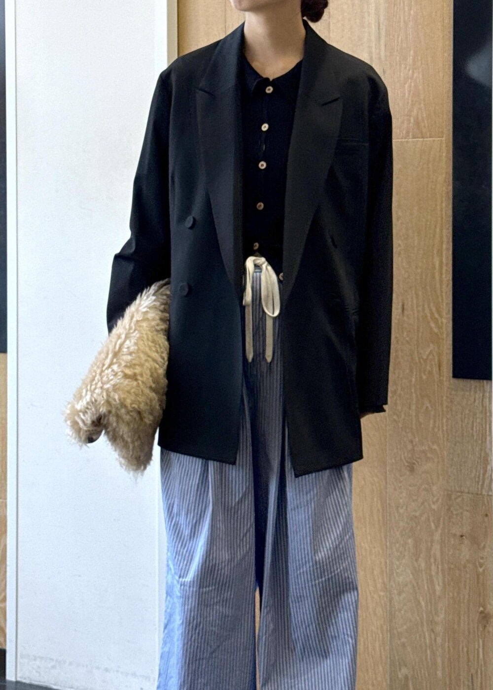 ブルー系のスラックス、ブラック系のテーラードジャケット、ベージュ系のトートバッグを着用したレディースの秋コーディネートの4枚目の写真