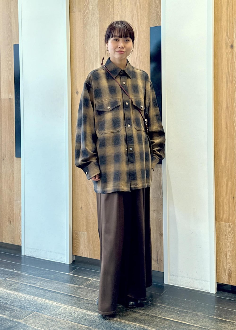 ブラック系のブーツ、ブラウン系のスカート、イエロー系のシャツ/ブラウスを着用したレディースの秋コーディネートの2枚目の写真