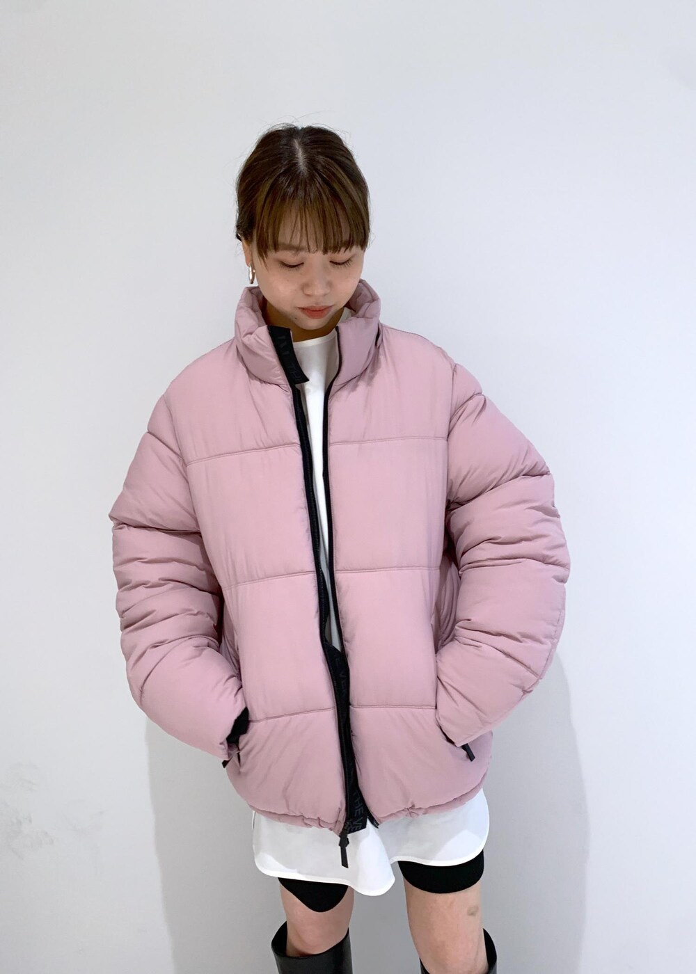 ブラック系のブーツ、ピンク系のダウンジャケット/コート、ブラック系のその他パンツを着用したレディースの秋コーディネートの6枚目の写真