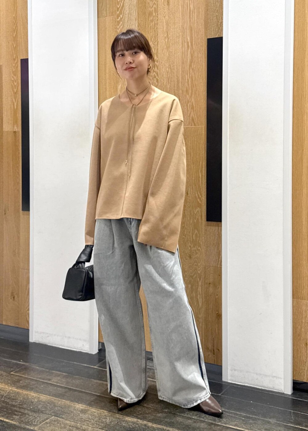 ブラウン系のブーツ、ベージュ系のTシャツ/カットソー、ブルー系のデニムパンツを着用したレディースの秋コーディネートの2枚目の写真