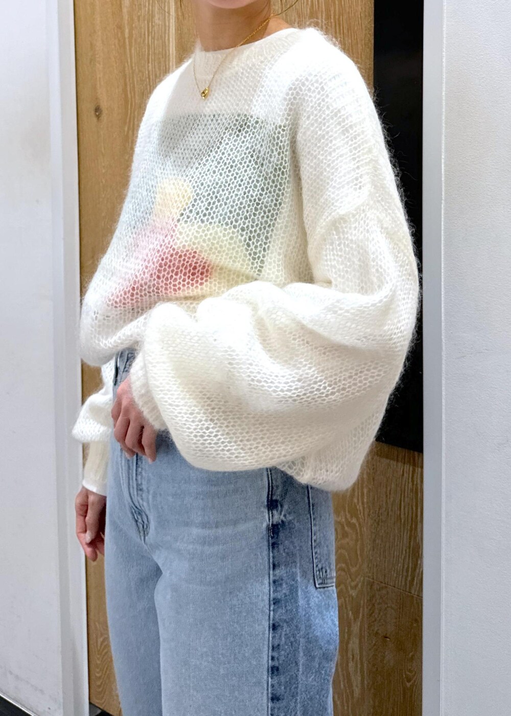 ホワイト系のニット/セーター、ホワイト系のボストンバッグ、ホワイト系のTシャツ/カットソーを着用したレディースの冬コーディネートの5枚目の写真