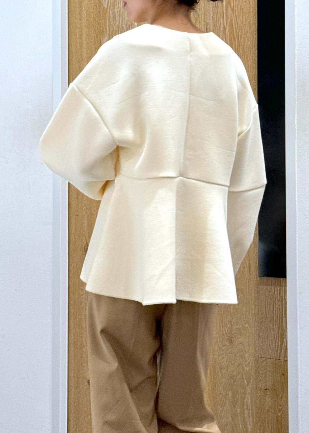 ブラック系のブーツ、ホワイト系のカーディガン/ボレロ、ベージュ系のスラックスを着用したレディースの秋コーディネートの7枚目の写真