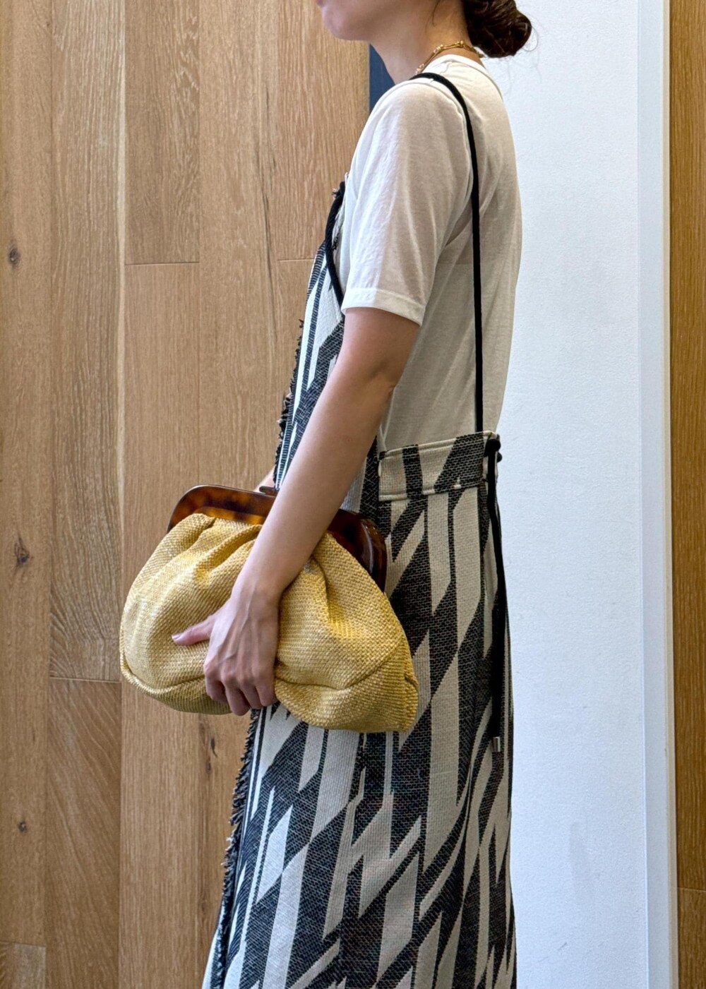 ゴールド系のサンダル、ホワイト系のTシャツ/カットソー、ブラック系のワンピースを着用したレディースの春コーディネートの7枚目の写真