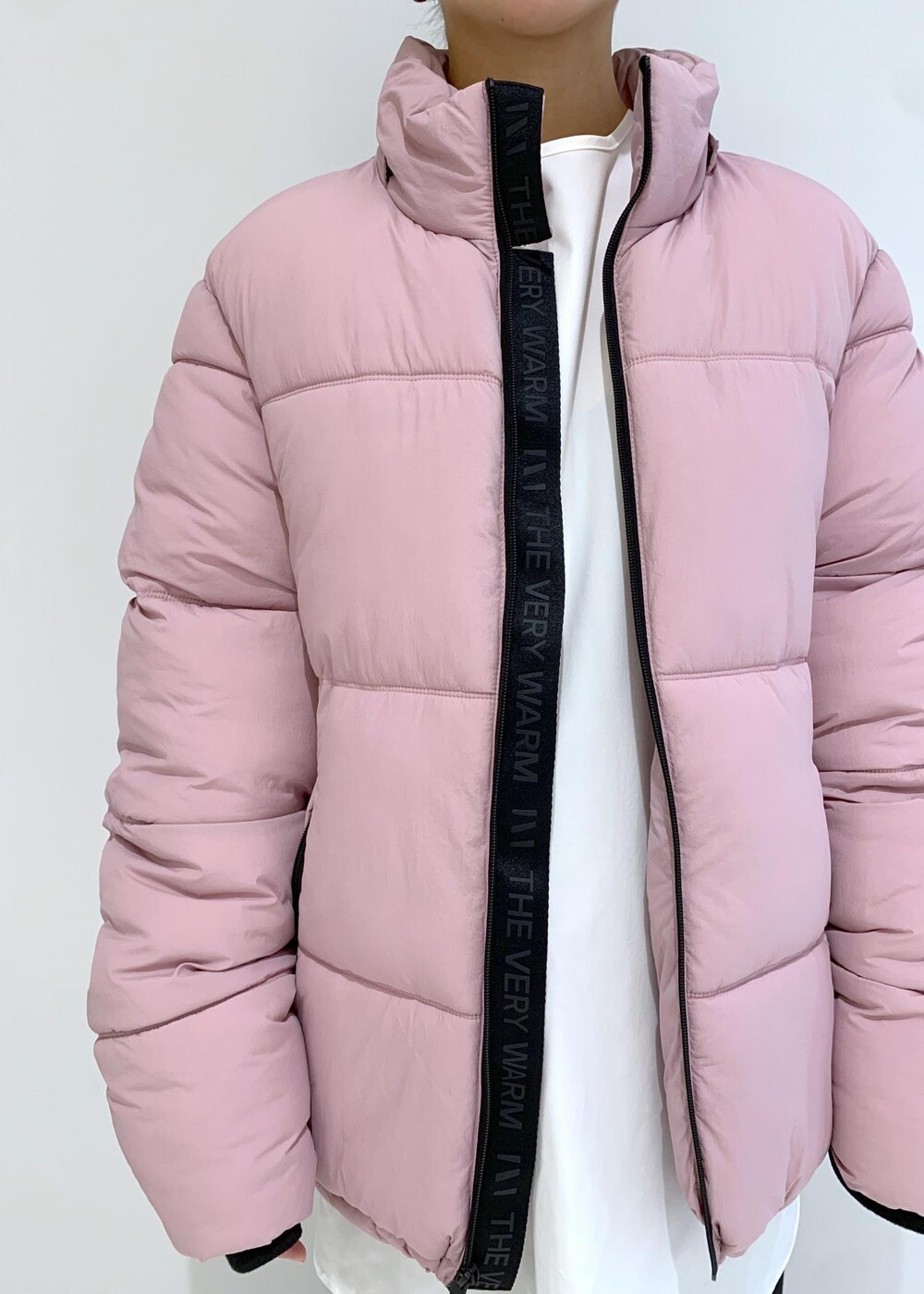 ブラック系のブーツ、ピンク系のダウンジャケット/コート、ブラック系のその他パンツを着用したレディースの秋コーディネートの5枚目の写真