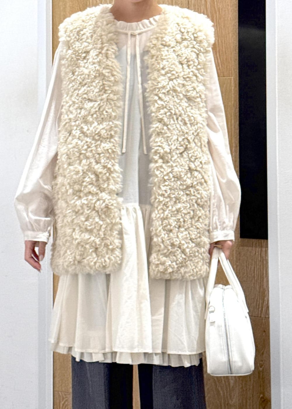 ベージュ系のその他アウター、ホワイト系のボストンバッグ、グレー系のスラックスを着用したレディースの冬コーディネートの5枚目の写真