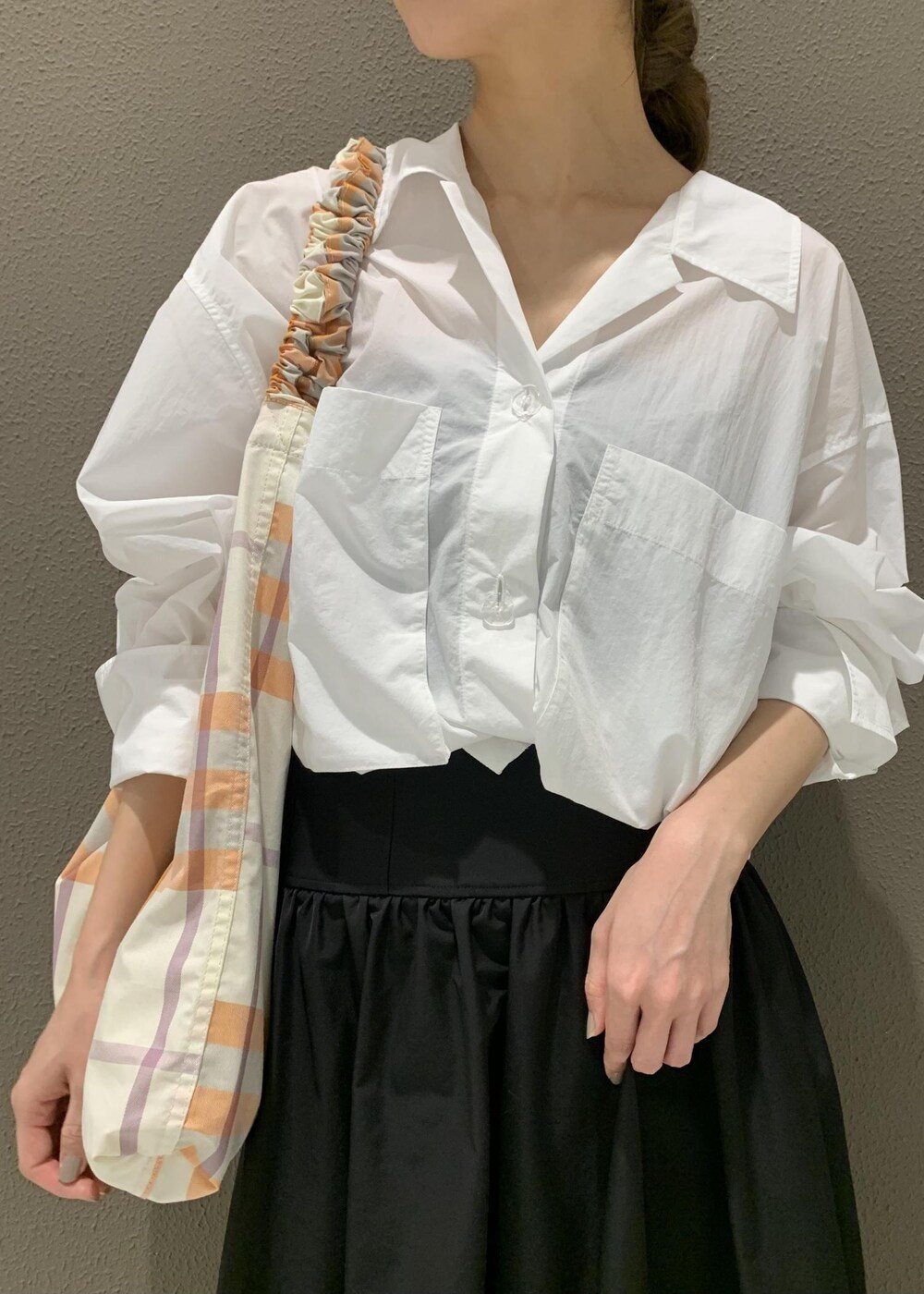 ブラック系のスカート、ホワイト系のサンダル、ホワイト系のシャツ/ブラウスを着用したレディースの春コーディネートの6枚目の写真