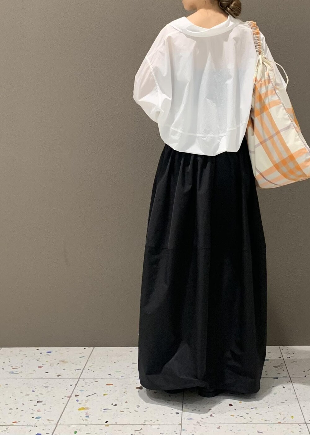 ブラック系のスカート、ホワイト系のサンダル、ホワイト系のシャツ/ブラウスを着用したレディースの春コーディネートの4枚目の写真