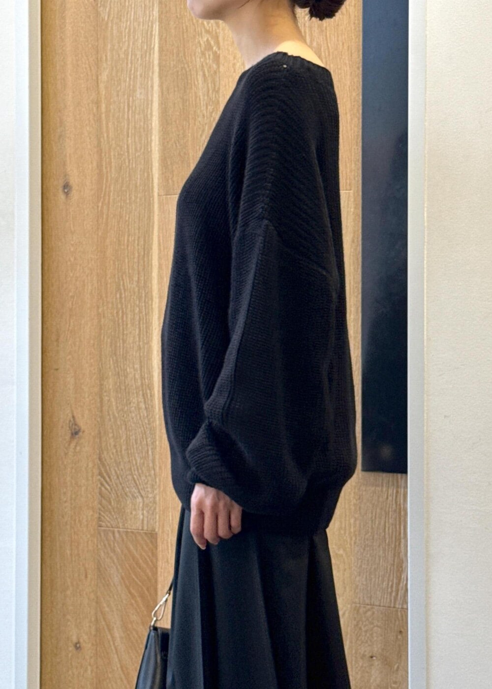 ブラック系のショルダーバッグ、ブラック系のスカート、ブラック系のブーツを着用したレディースの秋コーディネートの6枚目の写真