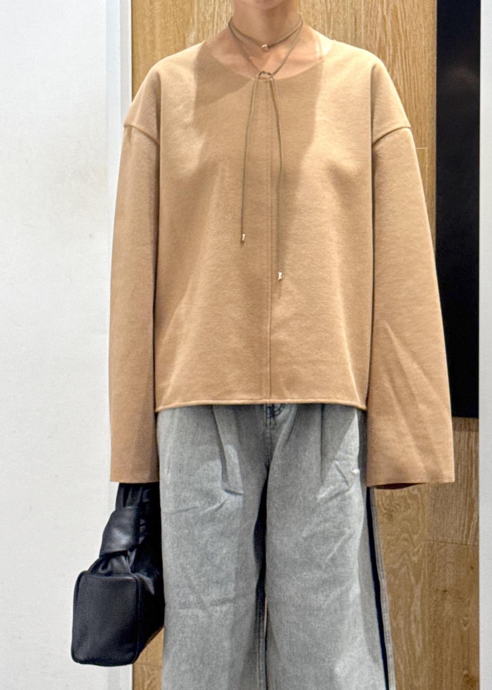 ブラウン系のブーツ、ベージュ系のTシャツ/カットソー、ブルー系のデニムパンツを着用したレディースの秋コーディネートの5枚目の写真