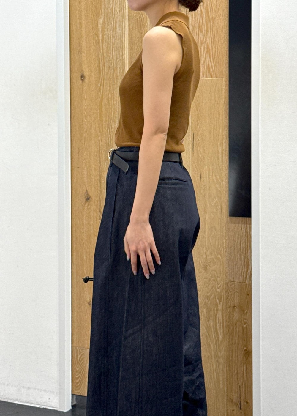 ブラウン系のニット/セーター、ブルー系のデニムパンツ、ブラック系のショルダーバッグを着用したレディースの夏コーディネートの6枚目の写真