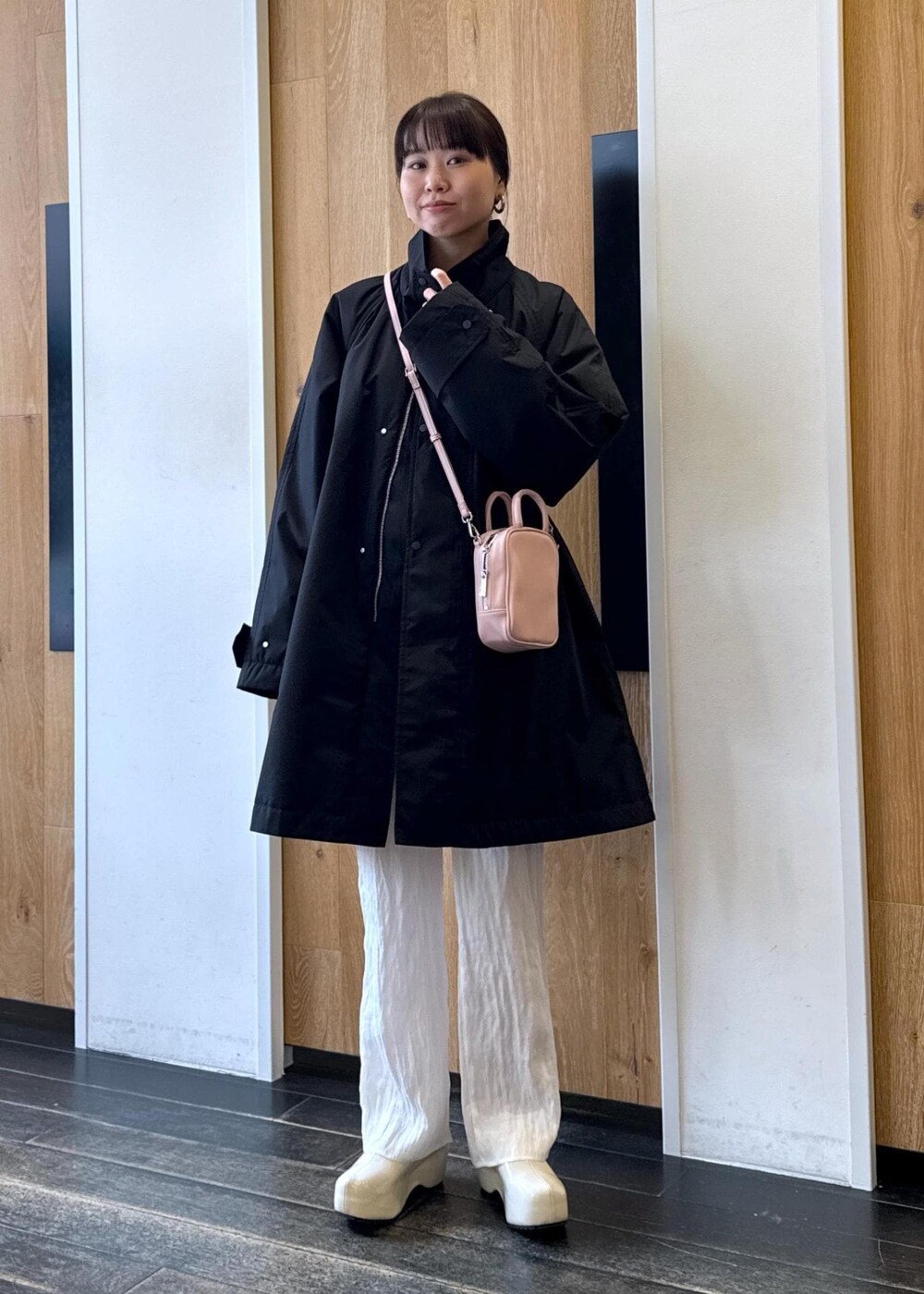 ピンク系のショルダーバッグ、ホワイト系のサンダル、ブラック系のスウェットを着用したレディースの冬コーディネートの2枚目の写真