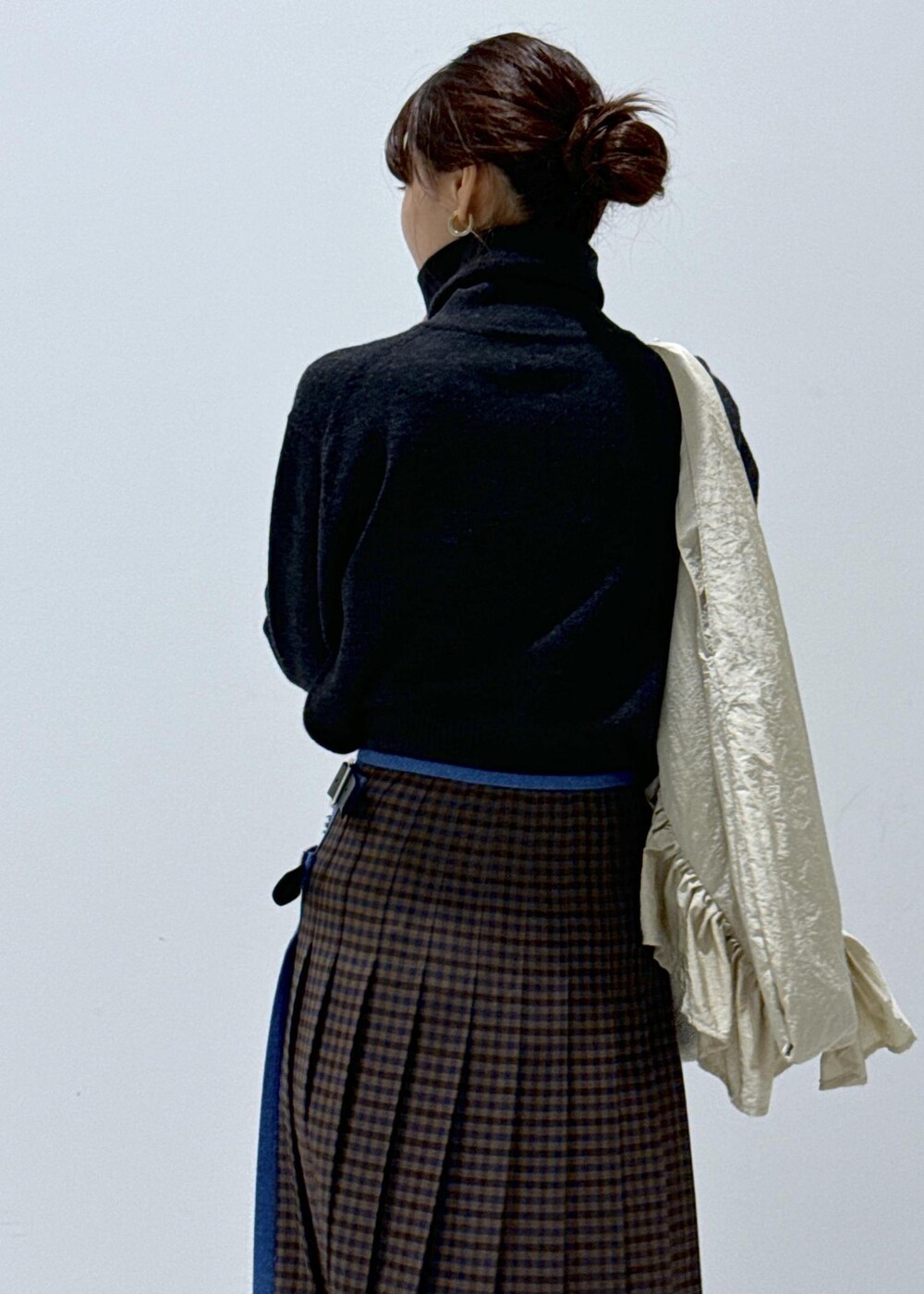 グレー系のスカート、ホワイト系のブーツ、グレー系のカーディガン/ボレロを着用したレディースの秋コーディネートの9枚目の写真