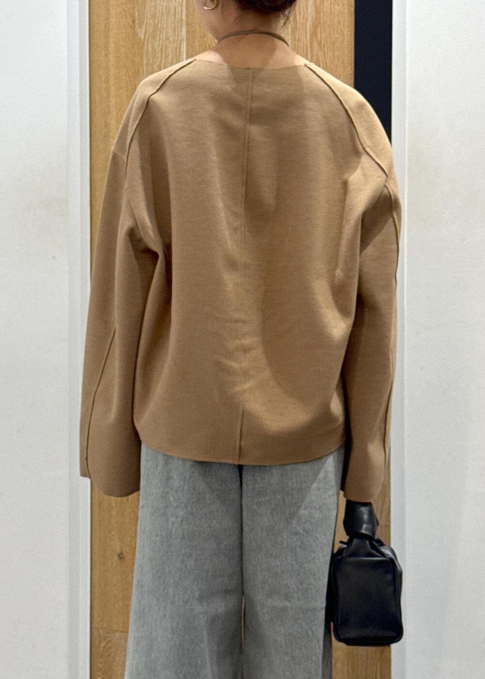 ブラウン系のブーツ、ベージュ系のTシャツ/カットソー、ブルー系のデニムパンツを着用したレディースの秋コーディネートの7枚目の写真