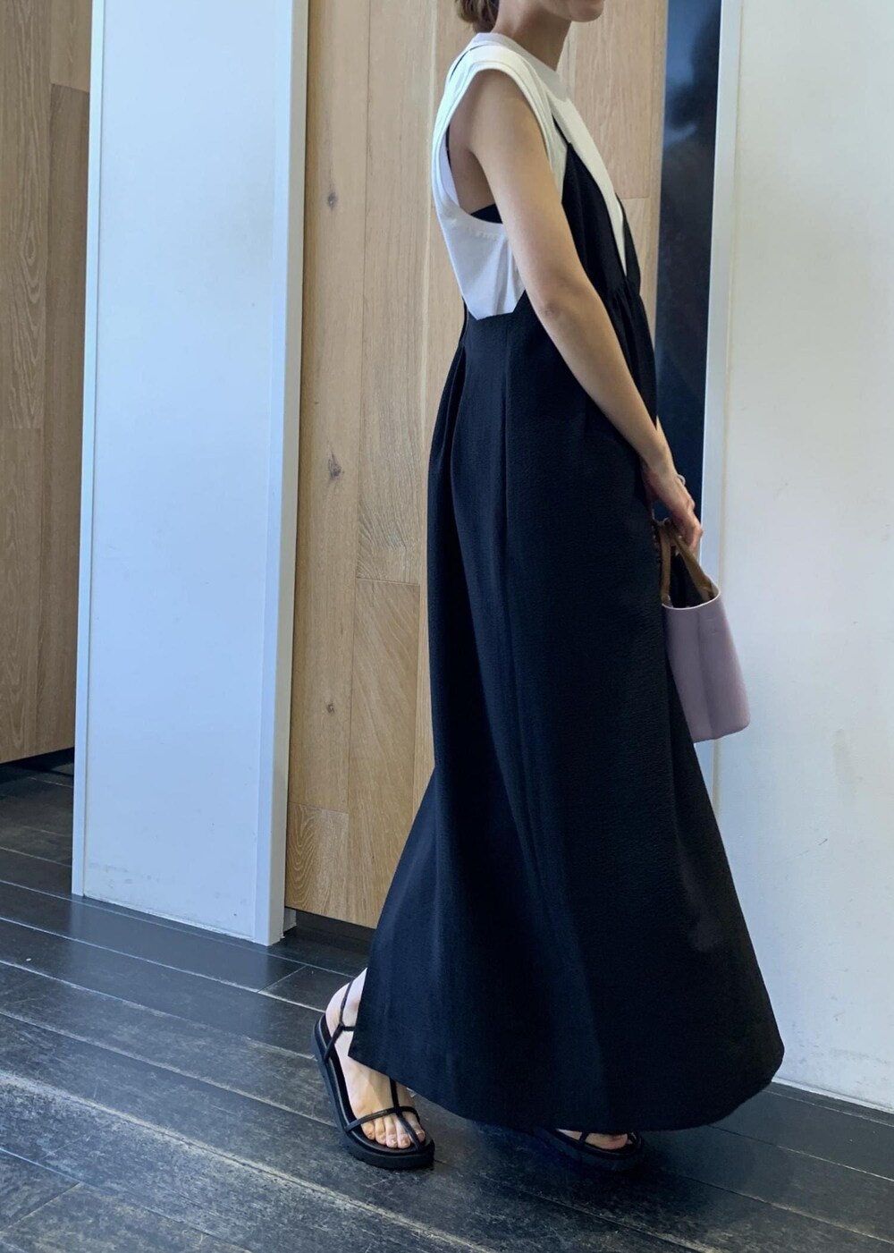 ブラック系のサンダル、ブラック系のワンピース、パープル系のショルダーバッグを着用したレディースの夏コーディネートの2枚目の写真