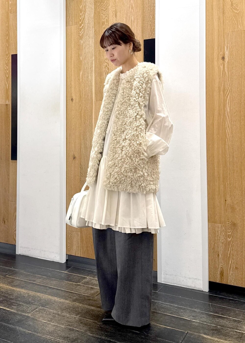 ベージュ系のその他アウター、ホワイト系のボストンバッグ、グレー系のスラックスを着用したレディースの冬コーディネートの3枚目の写真