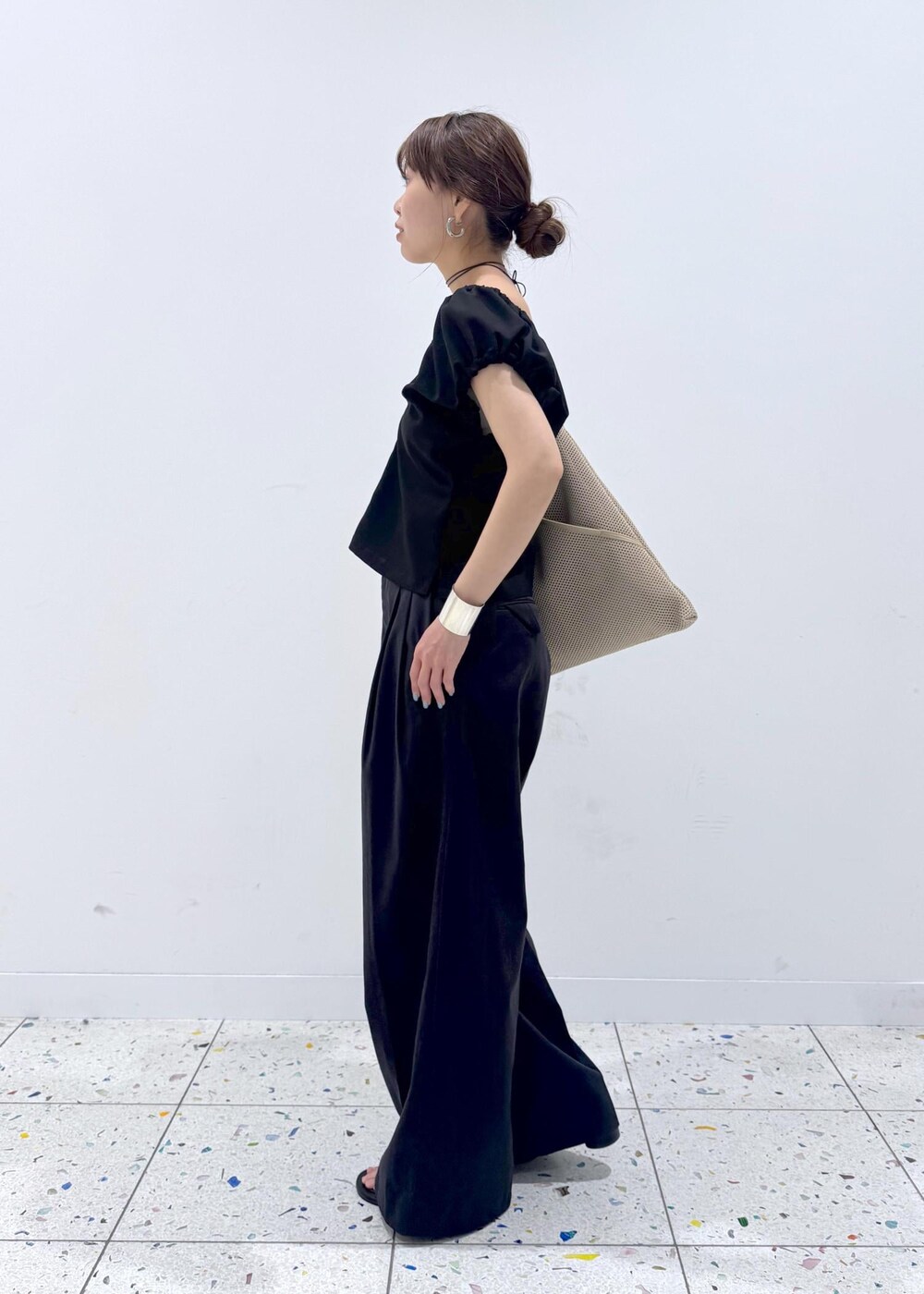 ベージュ系のショルダーバッグ、ブラック系のサンダル、ブラック系のその他パンツを着用したレディースの春コーディネートの2枚目の写真