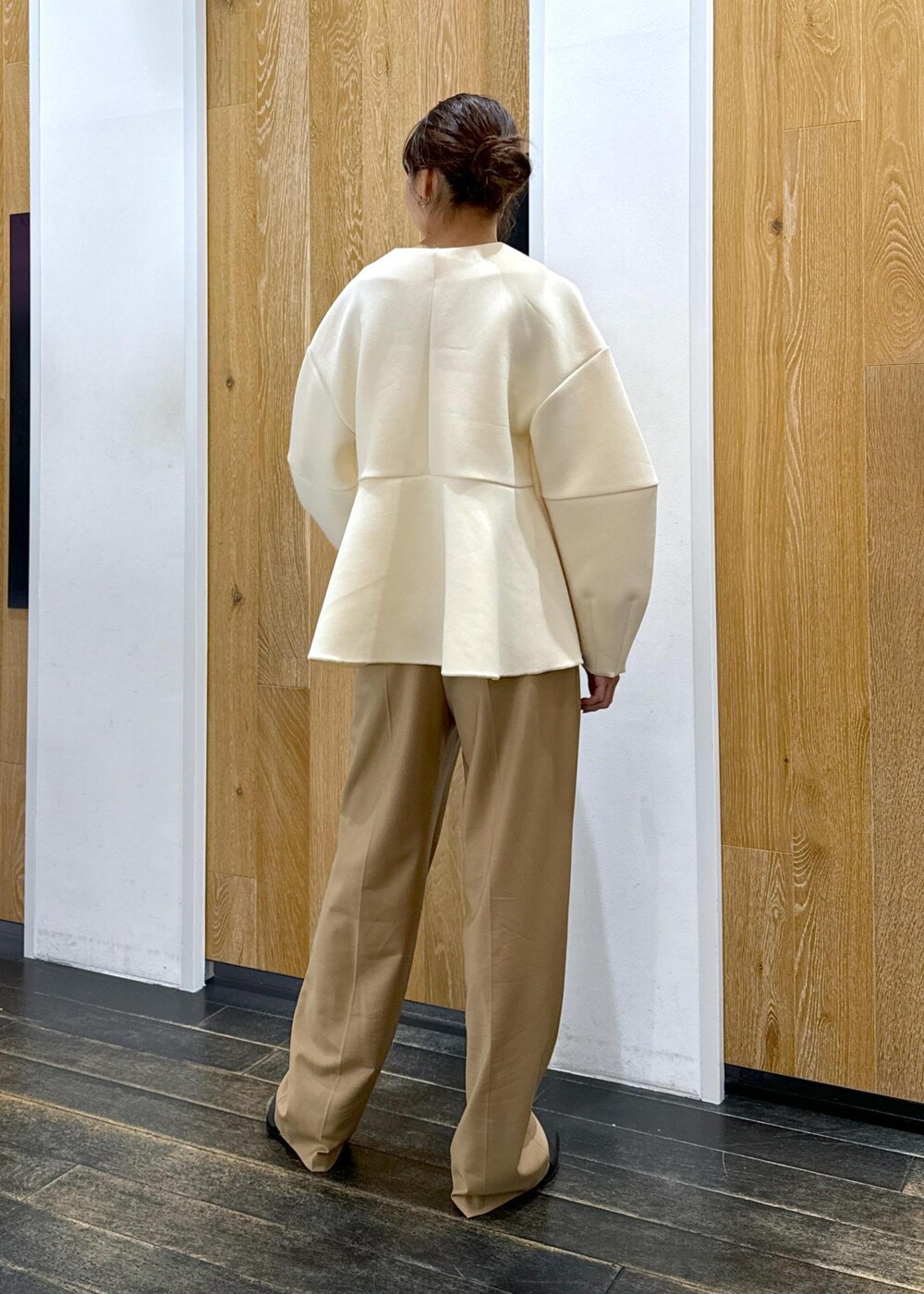 ブラック系のブーツ、ホワイト系のカーディガン/ボレロ、ベージュ系のスラックスを着用したレディースの秋コーディネートの4枚目の写真