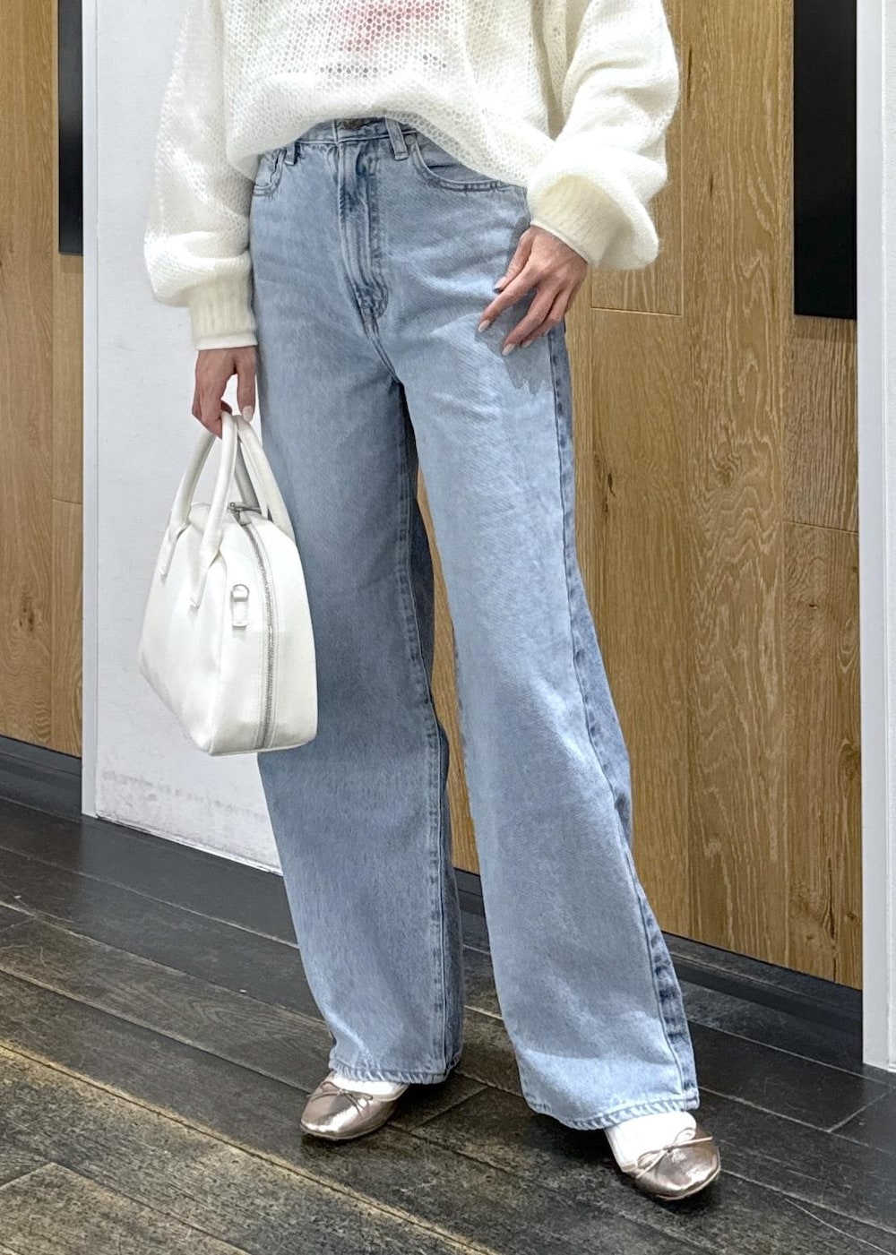 ホワイト系のニット/セーター、ホワイト系のボストンバッグ、ホワイト系のTシャツ/カットソーを着用したレディースの冬コーディネートの7枚目の写真