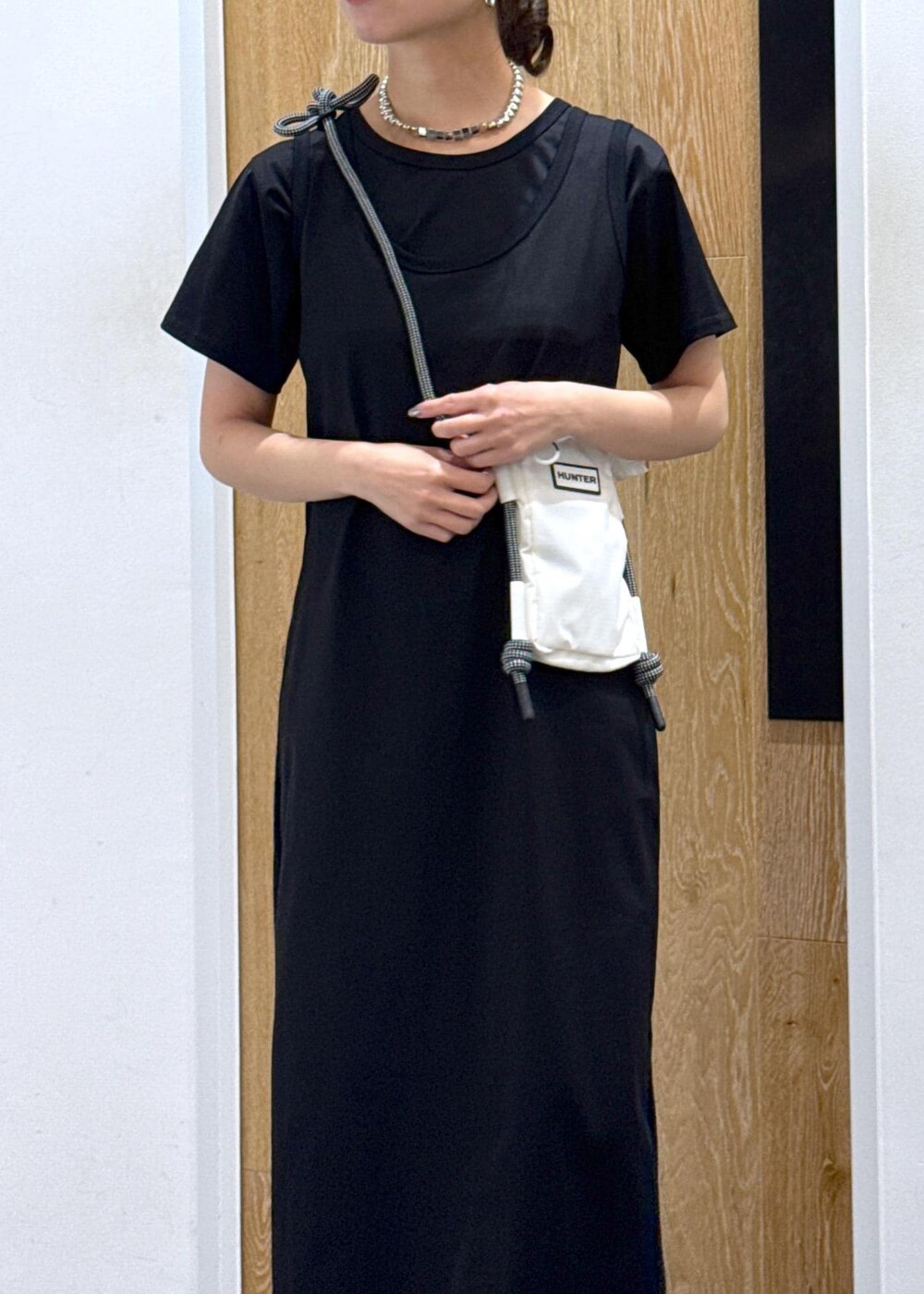 ブラック系のパンプス、ホワイト系のボディバッグ/ウエストポーチ、ブラック系のワンピースを着用したレディースの夏コーディネートの4枚目の写真