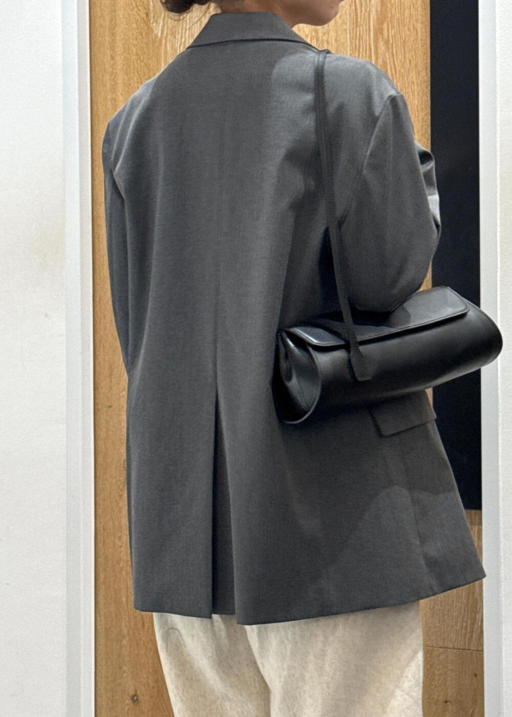 ブラック系のショルダーバッグ、グレー系のテーラードジャケット、ブラウン系のTシャツ/カットソーを着用したレディースの春コーディネートの6枚目の写真