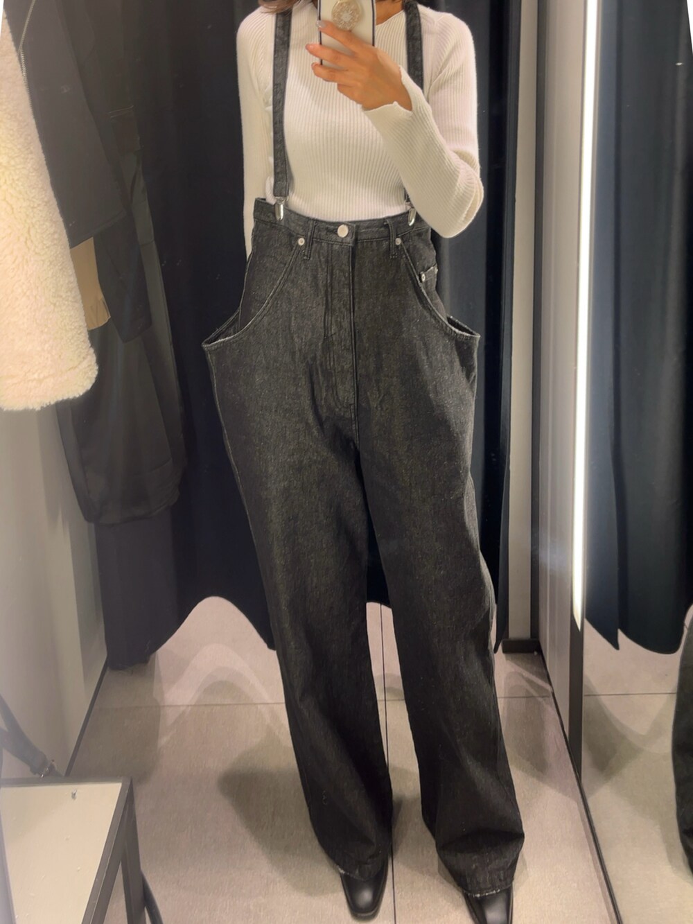 ブラック系のデニムパンツ、ホワイト系のジャケット/アウターを着用したレディースの冬コーディネートの2枚目の写真