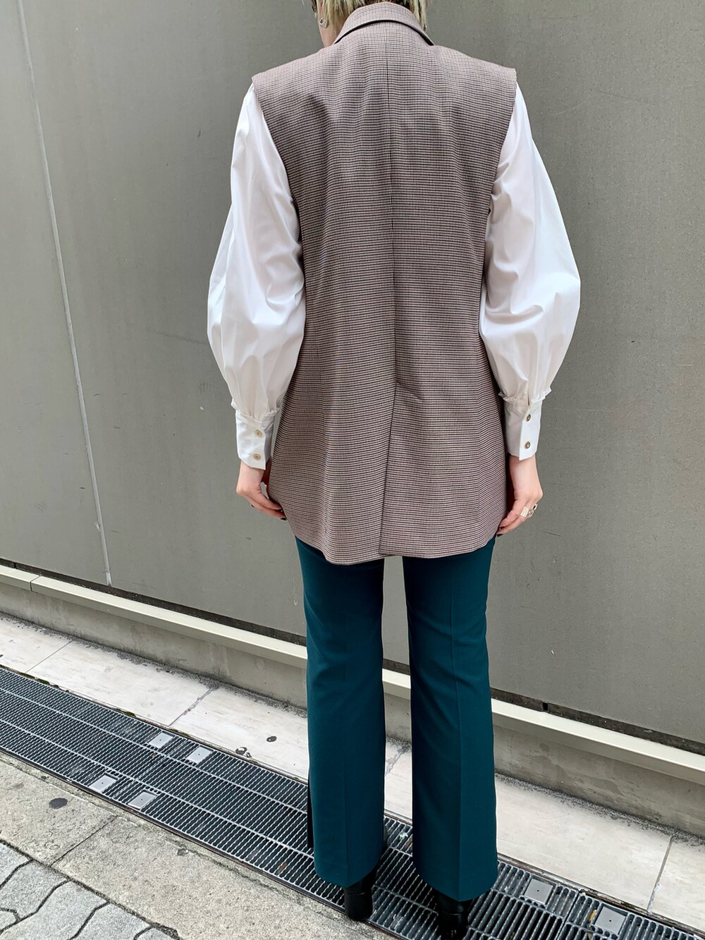 ホワイト系のトップス、グリーン系のその他パンツ、ベージュ系のベストを着用したレディースの秋コーディネートの2枚目の写真