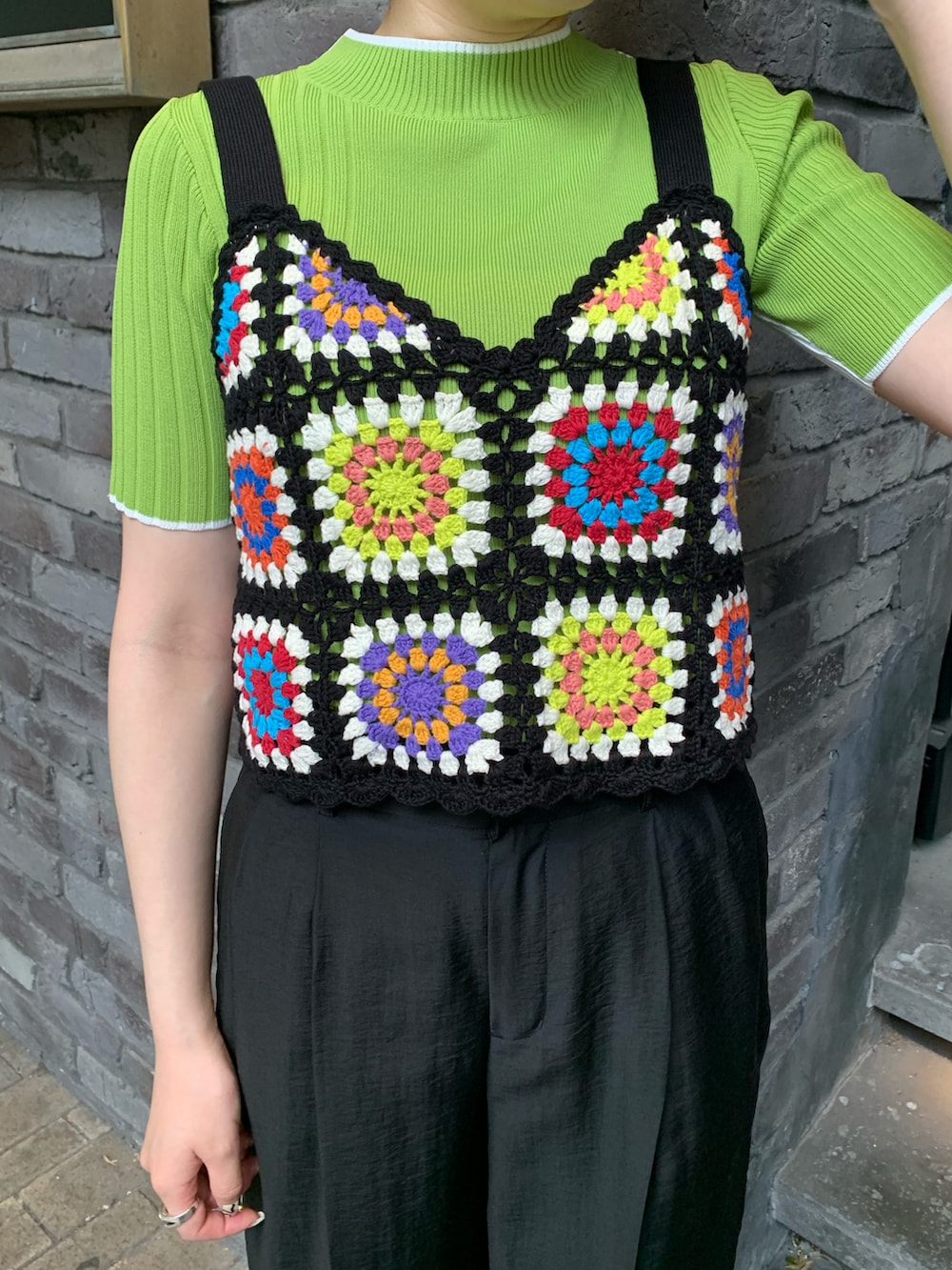 ブラック系のキャミソール、グリーン系のニット/セーター、ブラック系のスラックスを着用したレディースの春コーディネートの3枚目の写真