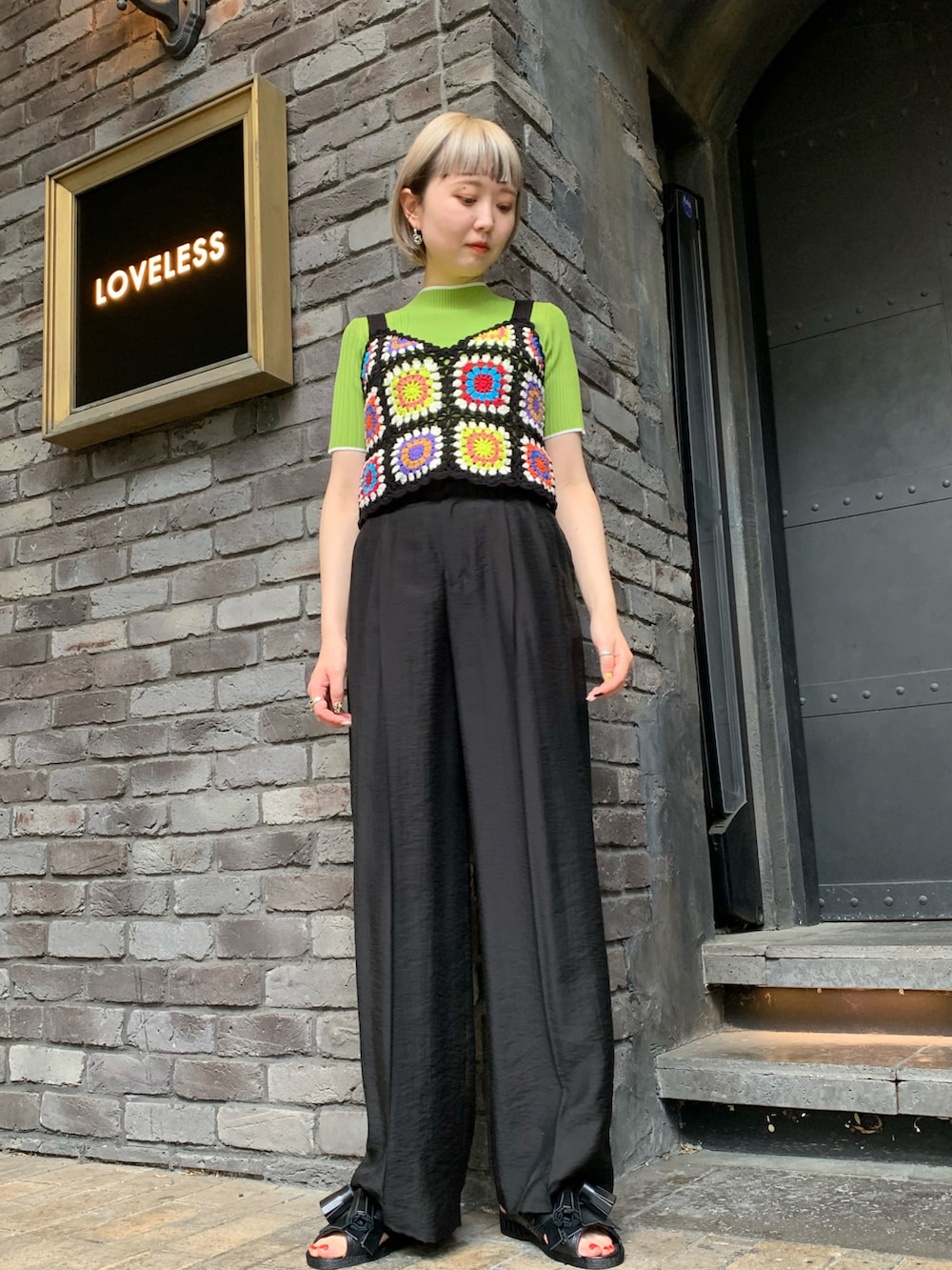 ブラック系のキャミソール、グリーン系のニット/セーター、ブラック系のスラックスを着用したレディースの春コーディネートの2枚目の写真