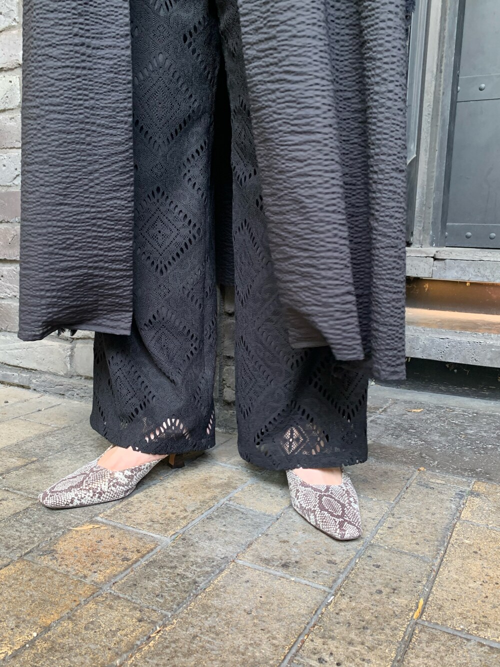 ブラック系のワンピース/ドレス、ブラック系のその他パンツ、ベージュ系のサンダルを着用したレディースの春コーディネートの5枚目の写真