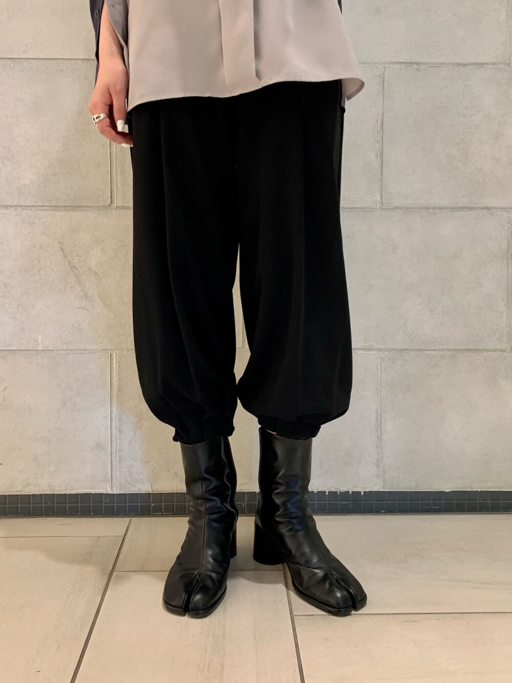 グレー系のシャツ/ブラウス、ブラック系のパンツ、ブラック系のブーツを着用したレディースの春コーディネートの3枚目の写真