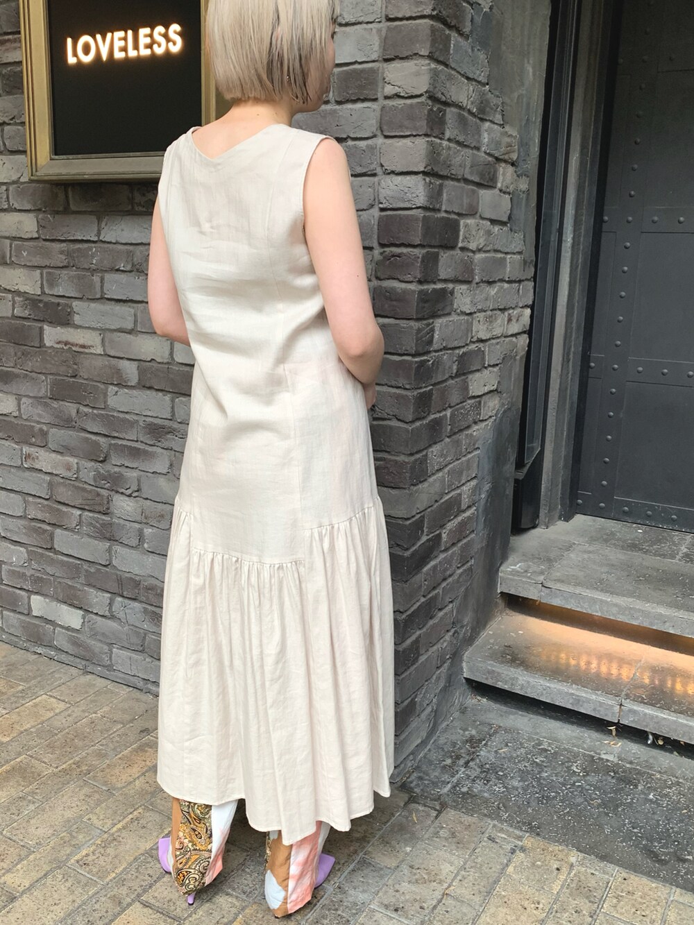 ベージュ系のワンピース、ベージュ系のパンツ、パープル系のシューズを着用したレディースの春コーディネートの2枚目の写真