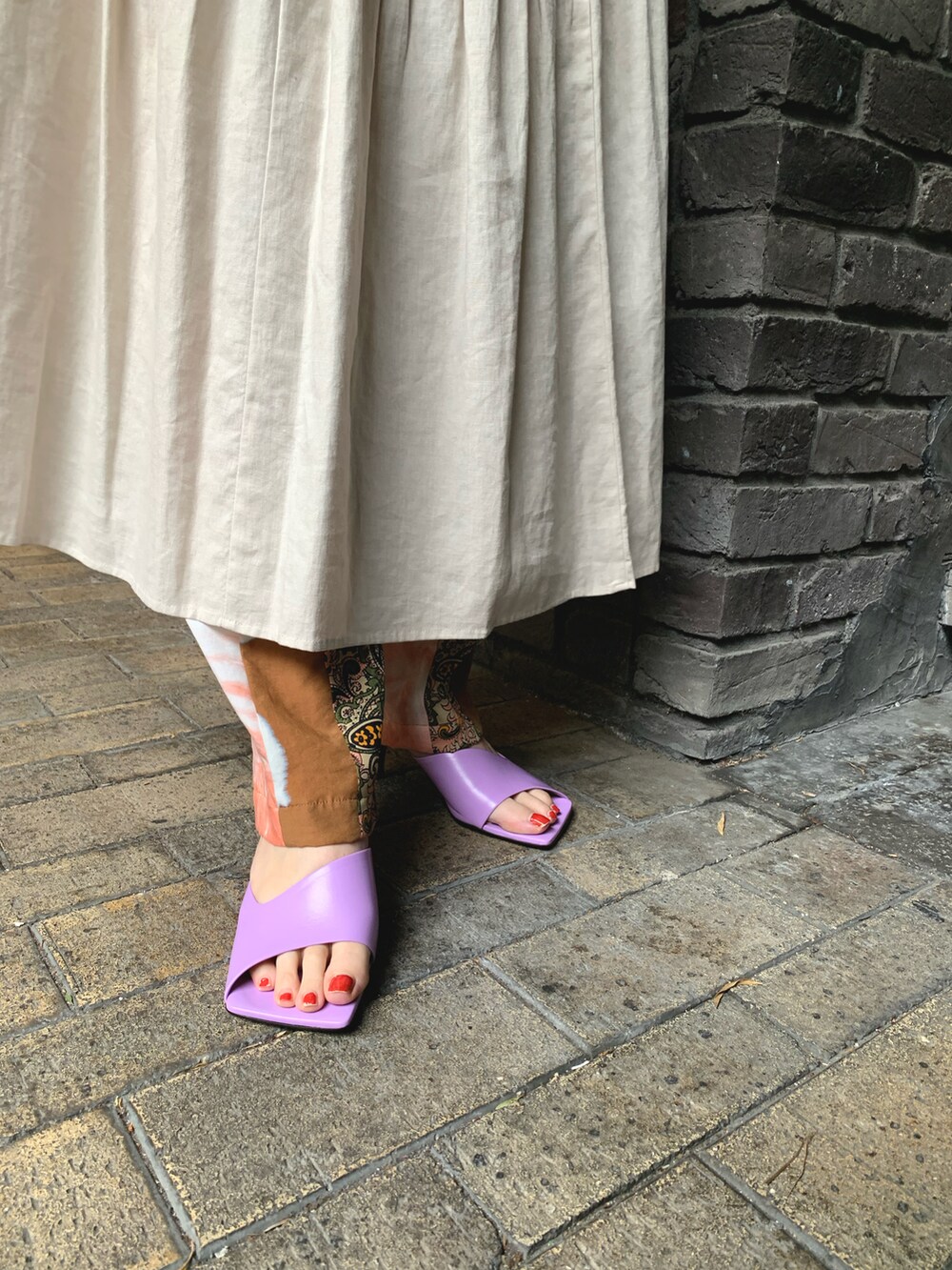 ベージュ系のワンピース、ベージュ系のパンツ、パープル系のシューズを着用したレディースの春コーディネートの4枚目の写真