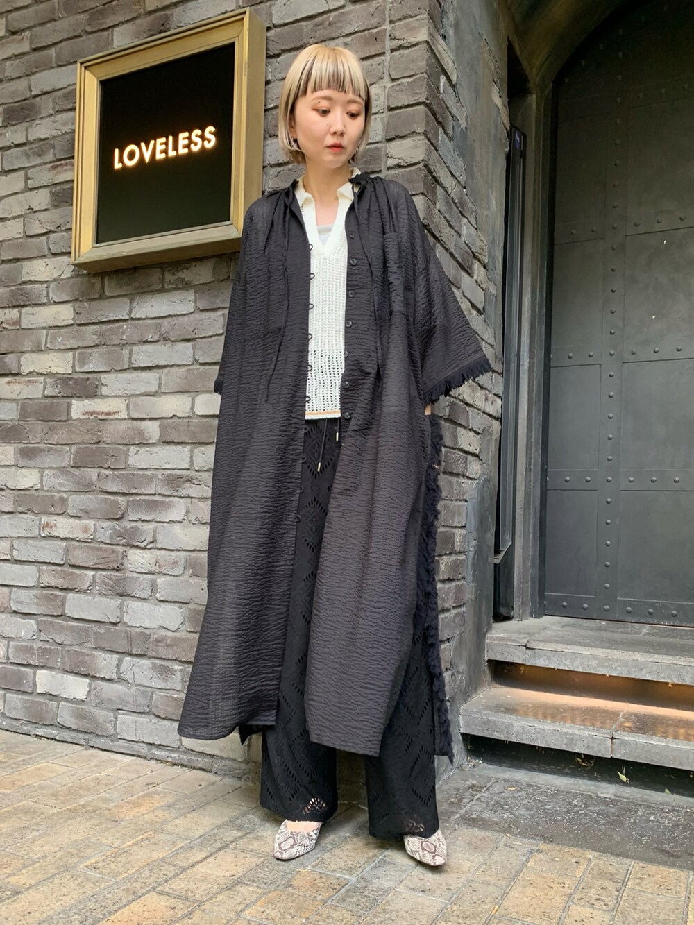 ブラック系のワンピース/ドレス、ブラック系のその他パンツ、ベージュ系のサンダルを着用したレディースの春コーディネートの2枚目の写真