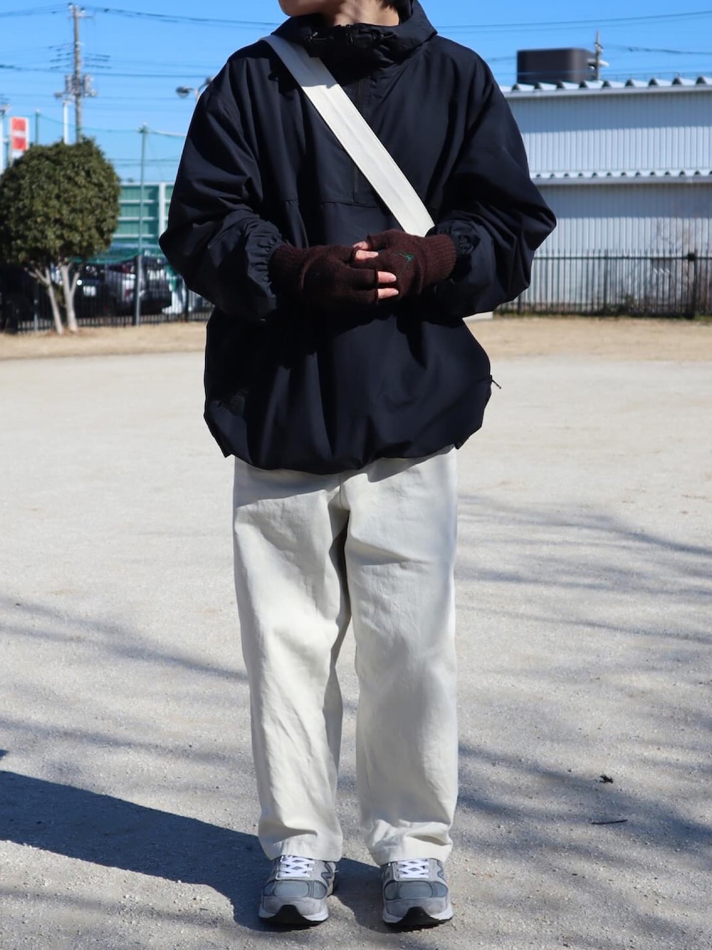 ブラック系のその他アウター、ベージュ系のチノパンツ、グレー系のスニーカーを着用したメンズの冬コーディネートの3枚目の写真