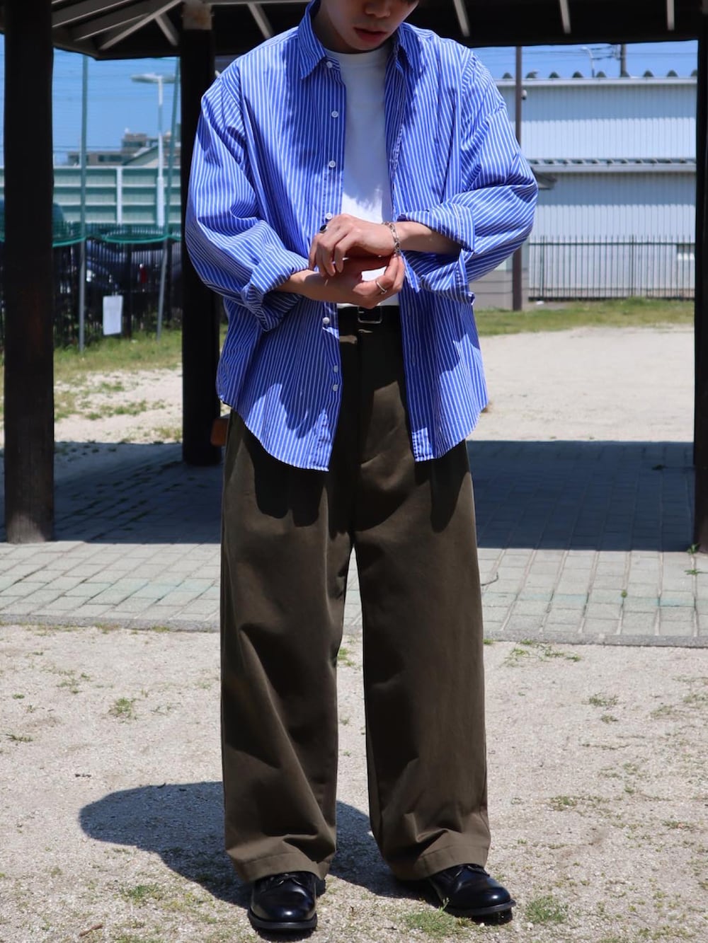 ブルー系のシャツ/ブラウス、ホワイト系のTシャツ/カットソー、グリーン系のチノパンツを着用したメンズの春コーディネートの3枚目の写真