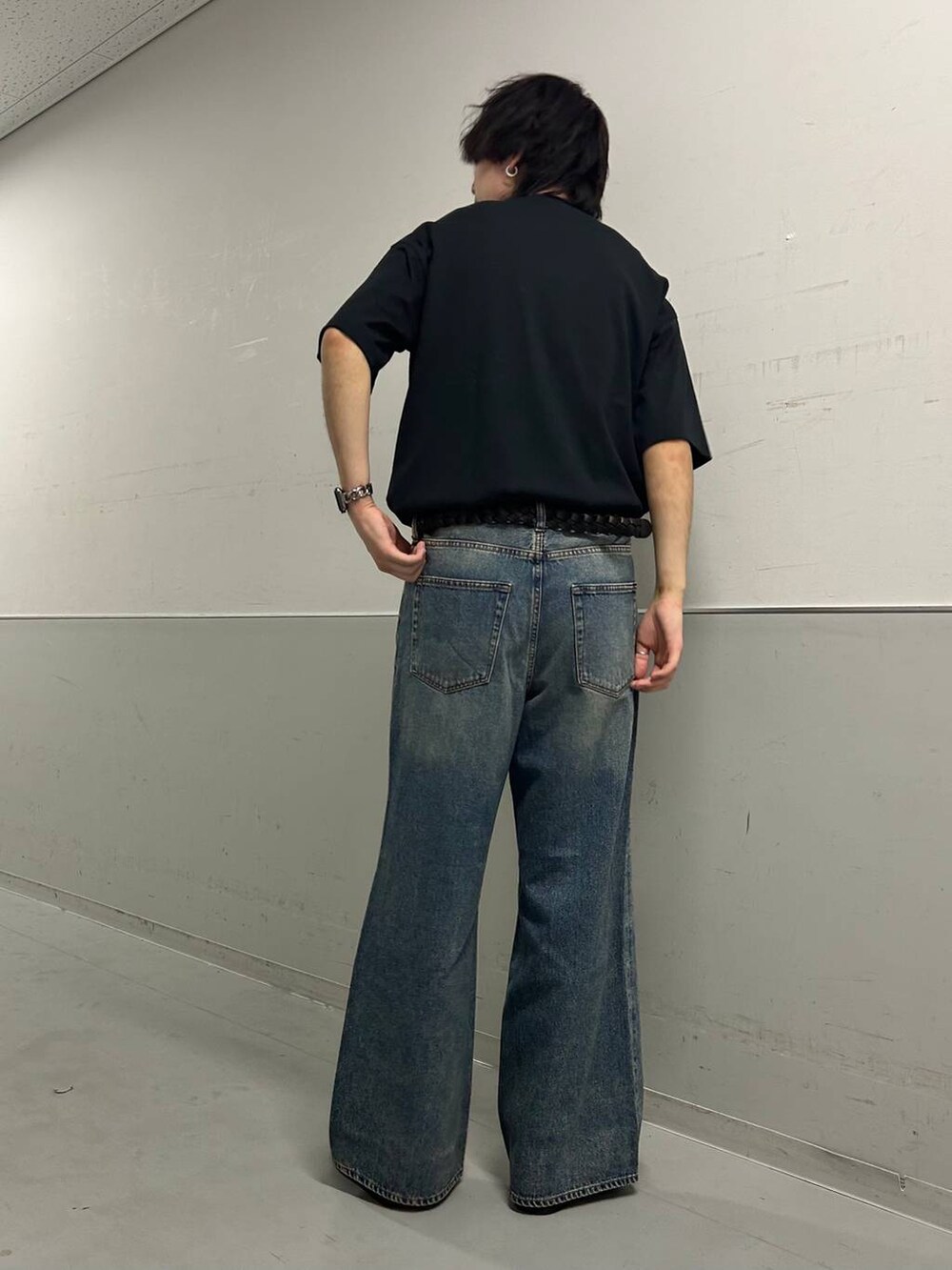 ブルー系のデニムパンツ、ブラック系のTシャツ/カットソー、ブラック系のベルトを着用したメンズの夏コーディネートの2枚目の写真