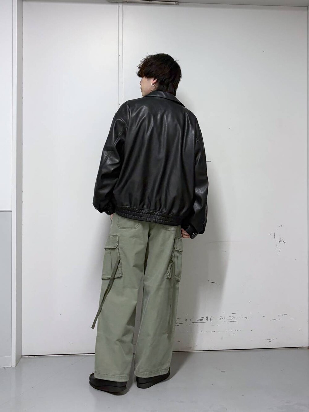 ブラック系のブルゾン、グリーン系のカーゴパンツ、ホワイト系のTシャツ/カットソーを着用したメンズの春コーディネートの3枚目の写真