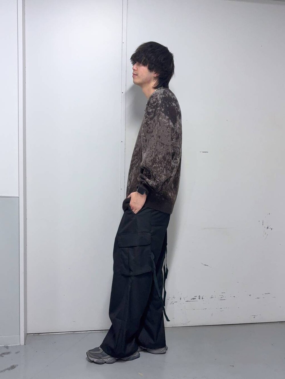 ブラウン系のニット/セーター、ブラック系のスラックス、ブルー系のソックス/靴下を着用したメンズの冬コーディネートの3枚目の写真