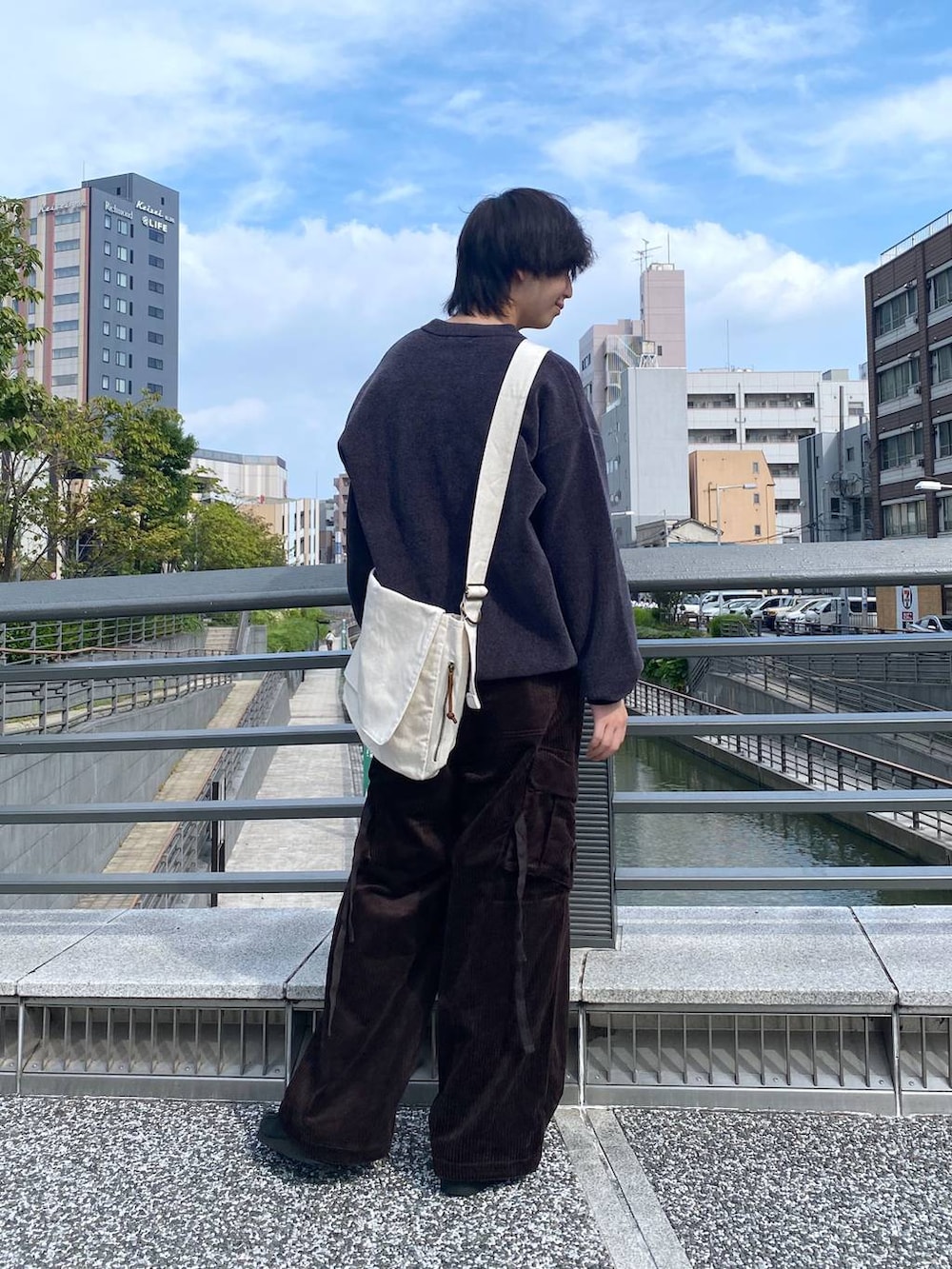 ブラウン系のカーゴパンツ、ホワイト系のショルダーバッグ、グレー系のニット/セーターを着用したメンズの秋コーディネートの3枚目の写真