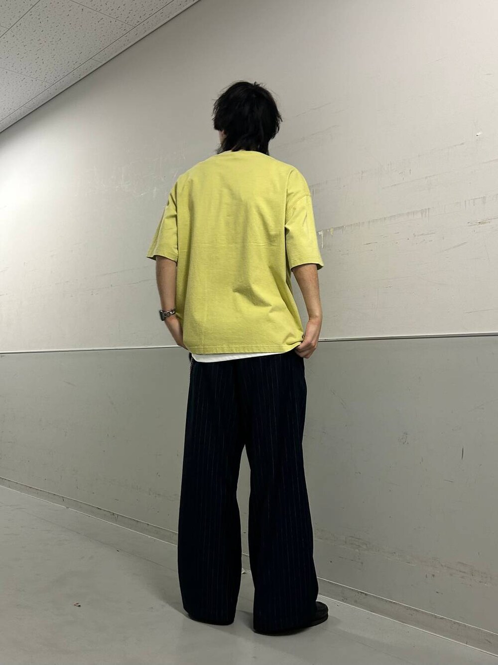 ホワイト系のタンクトップ、ブルー系のスラックス、グリーン系のTシャツ/カットソーを着用したメンズの夏コーディネートの3枚目の写真