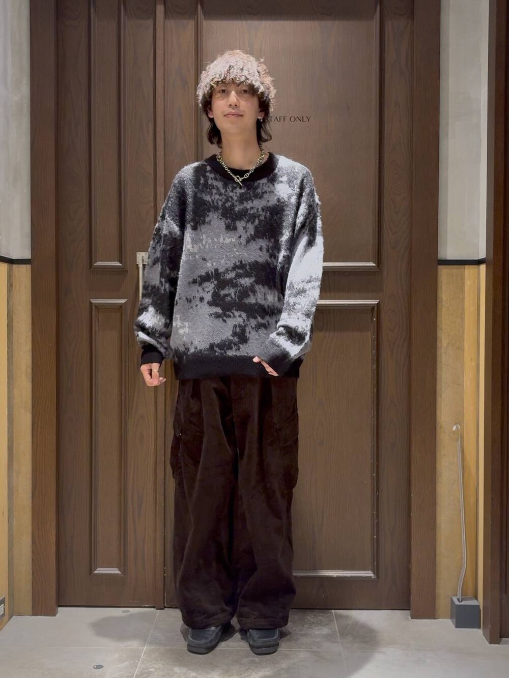 ブラウン系のカーゴパンツ、ブラック系のニット/セーター、ブルー系のソックス/靴下を着用したメンズの秋コーディネートの2枚目の写真