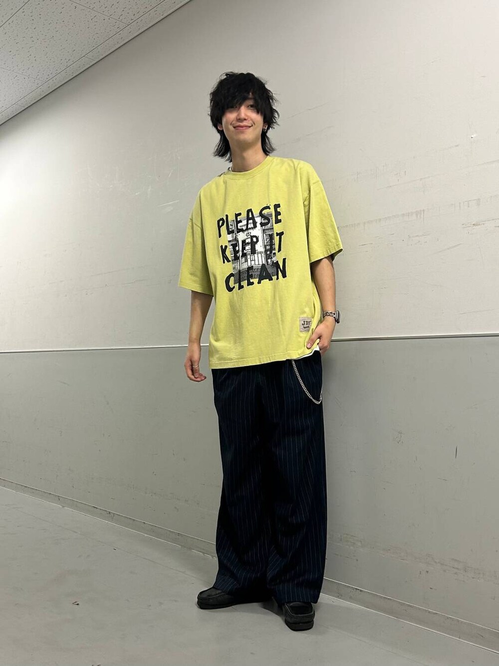 ホワイト系のタンクトップ、ブルー系のスラックス、グリーン系のTシャツ/カットソーを着用したメンズの夏コーディネートの4枚目の写真