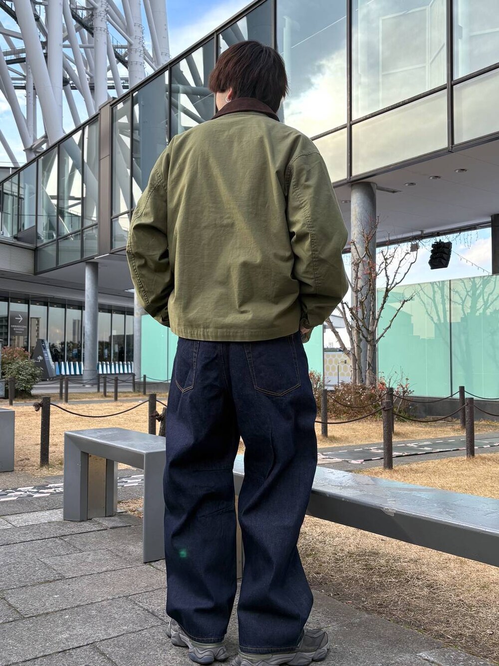 グリーン系のブルゾン、ブルー系のデニムパンツ、ブラック系のスウェットを着用したメンズの冬コーディネートの4枚目の写真