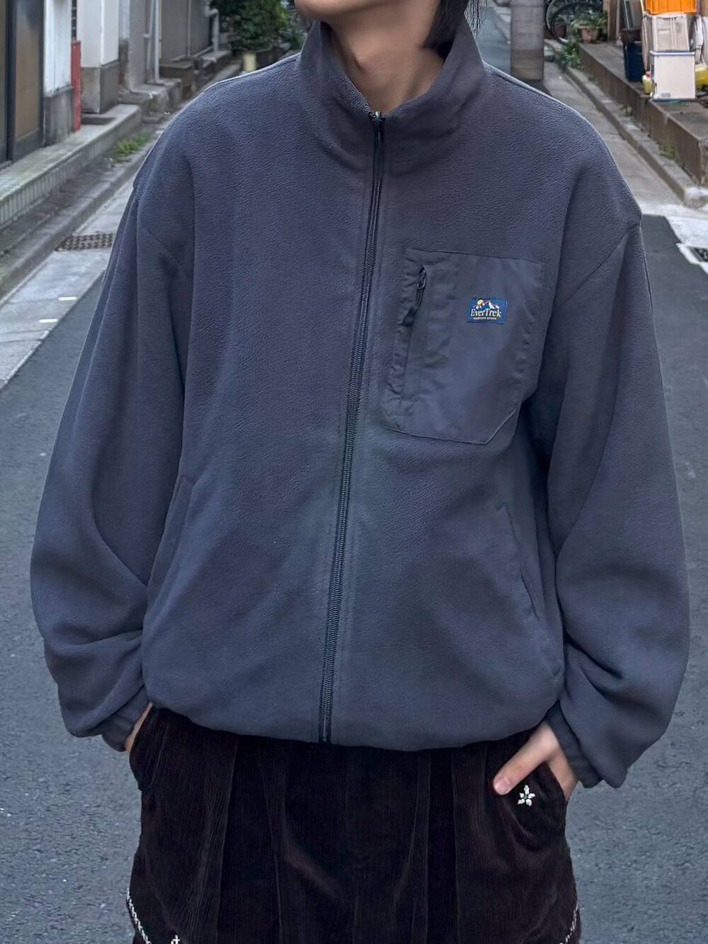 グレー系のブルゾン、ブラック系のニット/セーター、ブラウン系のカーゴパンツを着用したメンズの冬コーディネートの5枚目の写真