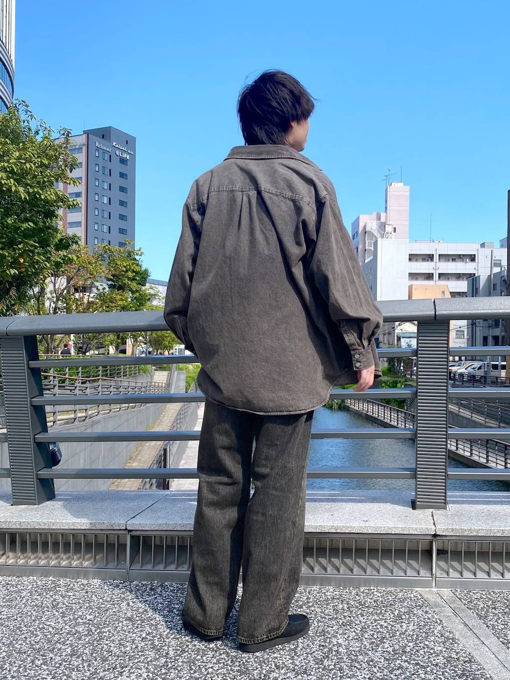 グレー系のデニムパンツ、ホワイト系のTシャツ/カットソー、ブラウン系のシャツ/ブラウスを着用したメンズの秋コーディネートの3枚目の写真