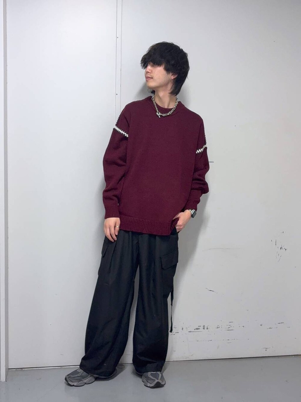 レッド系のニット/セーター、ブラック系のスラックス、ブルー系のソックス/靴下を着用したメンズの冬コーディネートの2枚目の写真